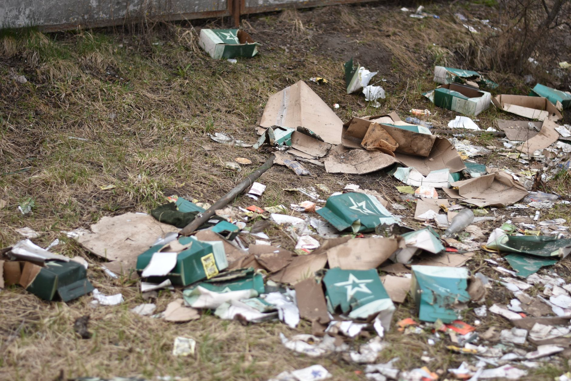 Pile of cardboard and litter scattered on a grassy urban area in Port St Lucie, the kind of curbside pickup a junk removal in my area search often turns up.