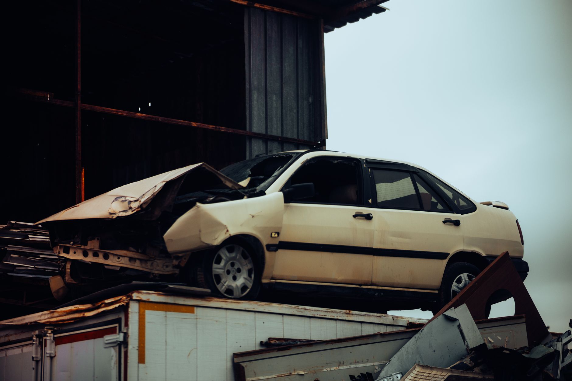 A damaged car on a scrap metal heap, an example of the oversized load worth describing when you call for a same-day pickup in Port St Lucie