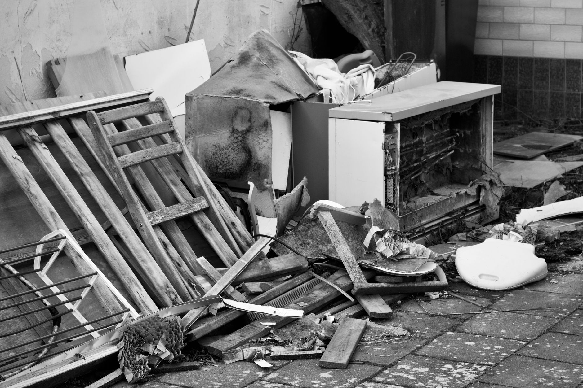 Black and white photo of a pile of discarded objects, similar to the loose items worth bagging and staging before a junk pickup