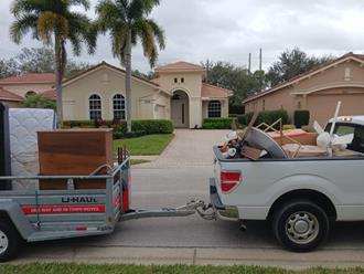 pickup truck with trailer loaded with junk from foreclosure clean out